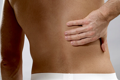 Person with spondylitis grabbing back